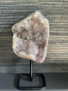 Natural amethyst form on black stand